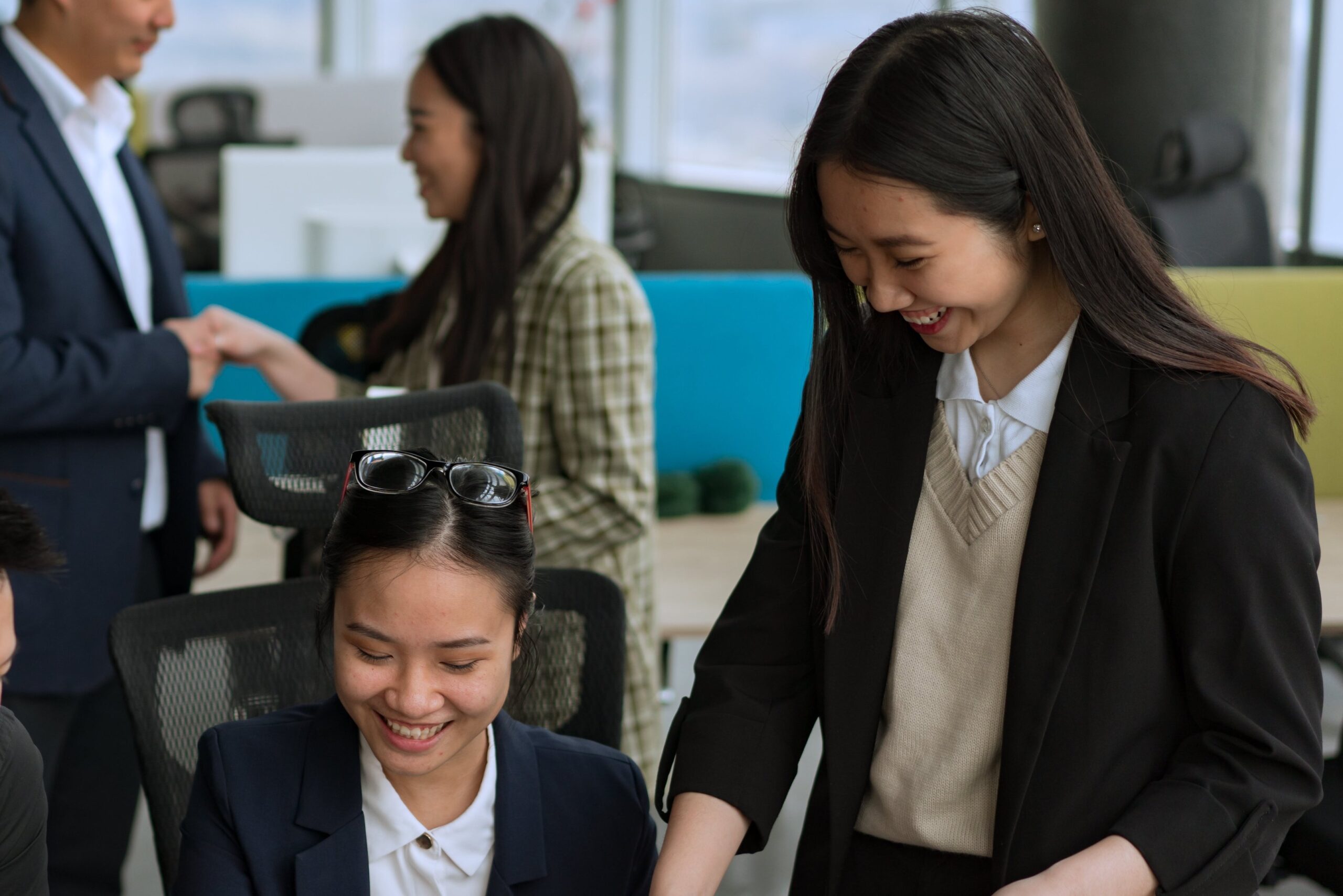 a woman in a suit and tie is smiling at a laptop